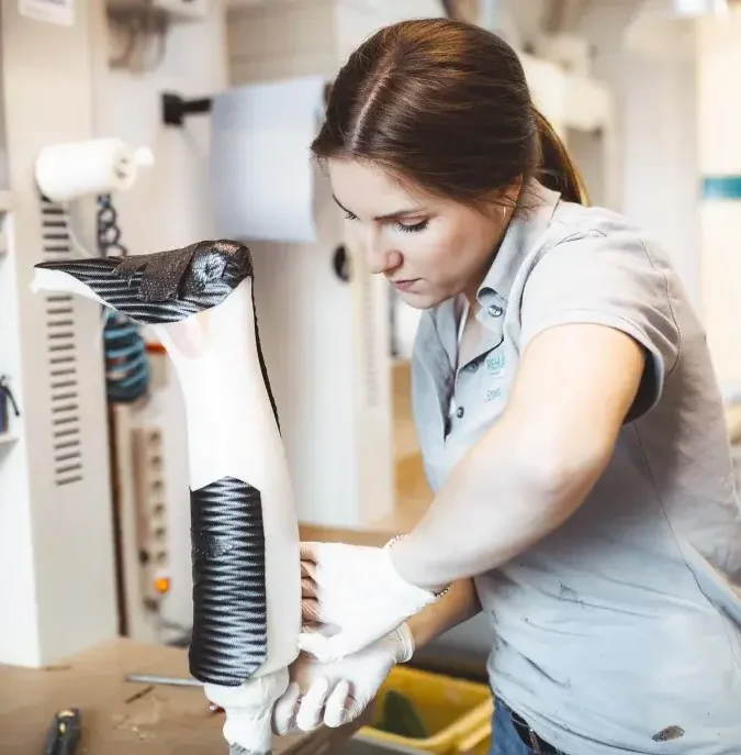 Eine Frau passt in einer Orthopädietechnik-Werkstatt eine Beinprothese an.