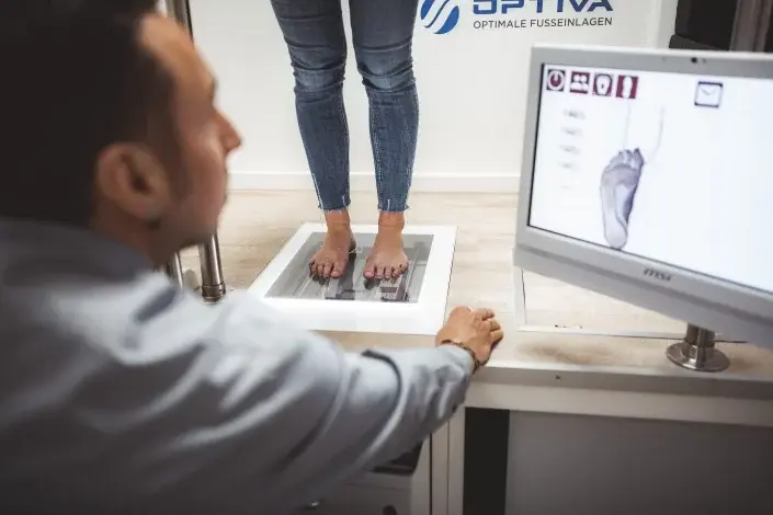 Person analysiert Fußdruckmessung für orthopädische Einlagen in Sanitätshaus Lüneburg.