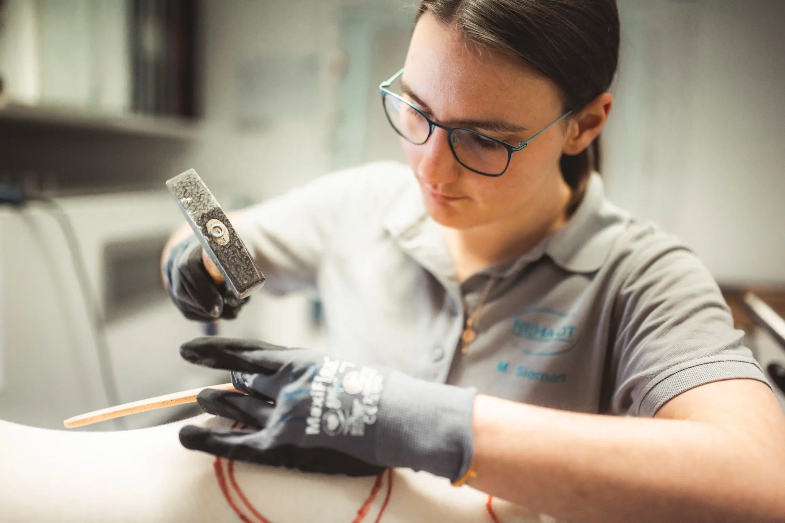 Eine Person bearbeitet in einer Orthopädietechnik-Werkstatt präzise eine Prothese.