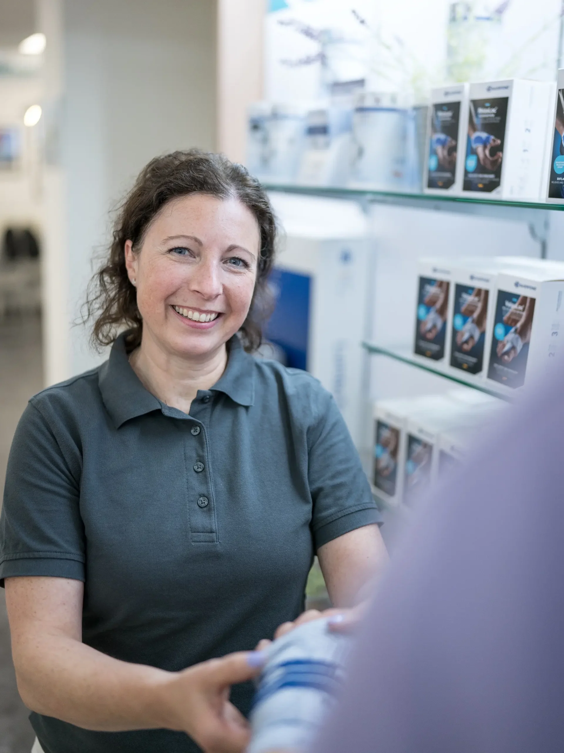 Mitarbeiterin in Sanitätshaus Lüneburg berät zu Rehatechnik-Produkten im Verkaufsraum.