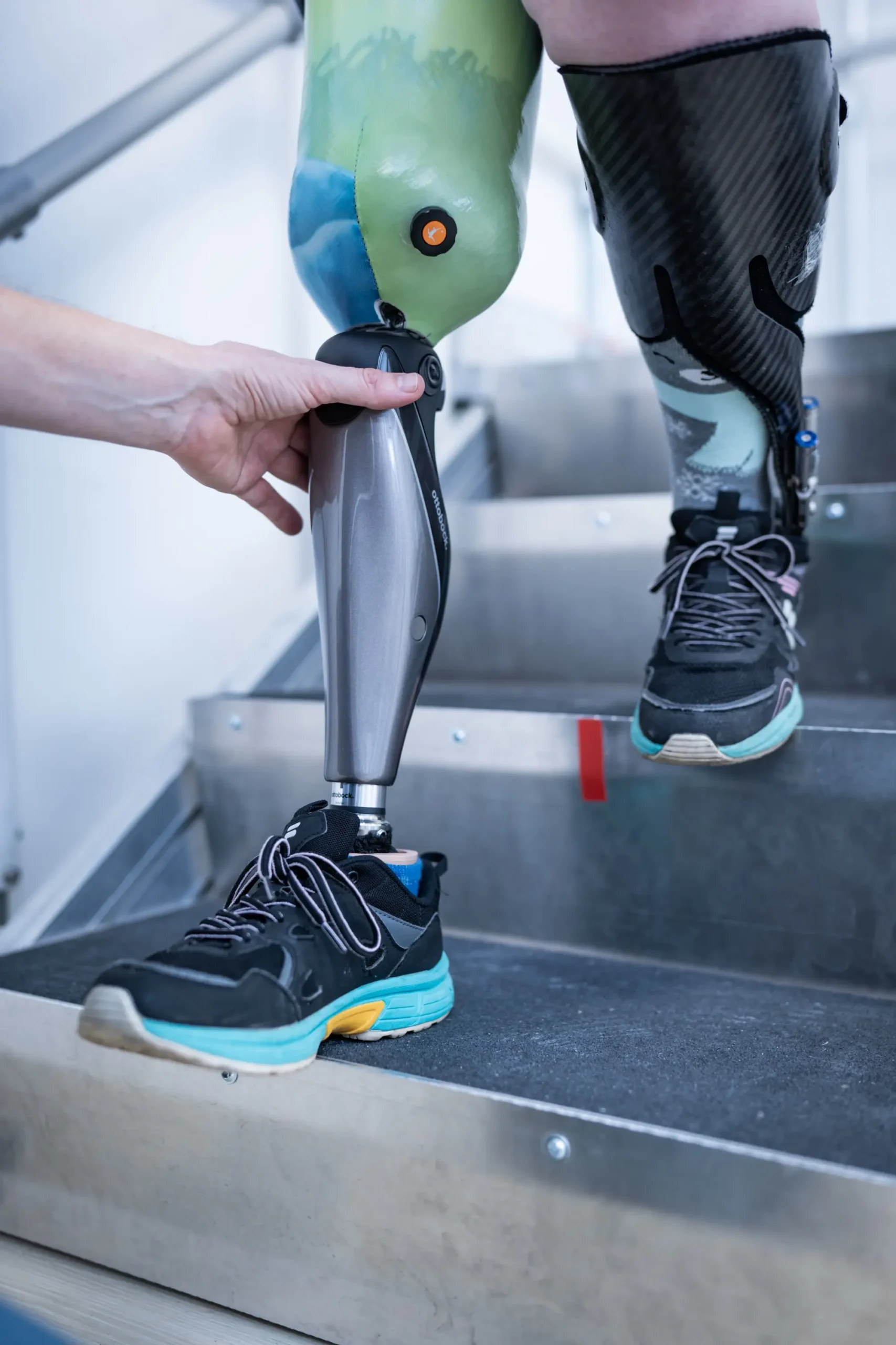 Person steigt mit Beinprothese eine Treppe hinab, unterstützt von Orthopädietechnik Lüneburg.