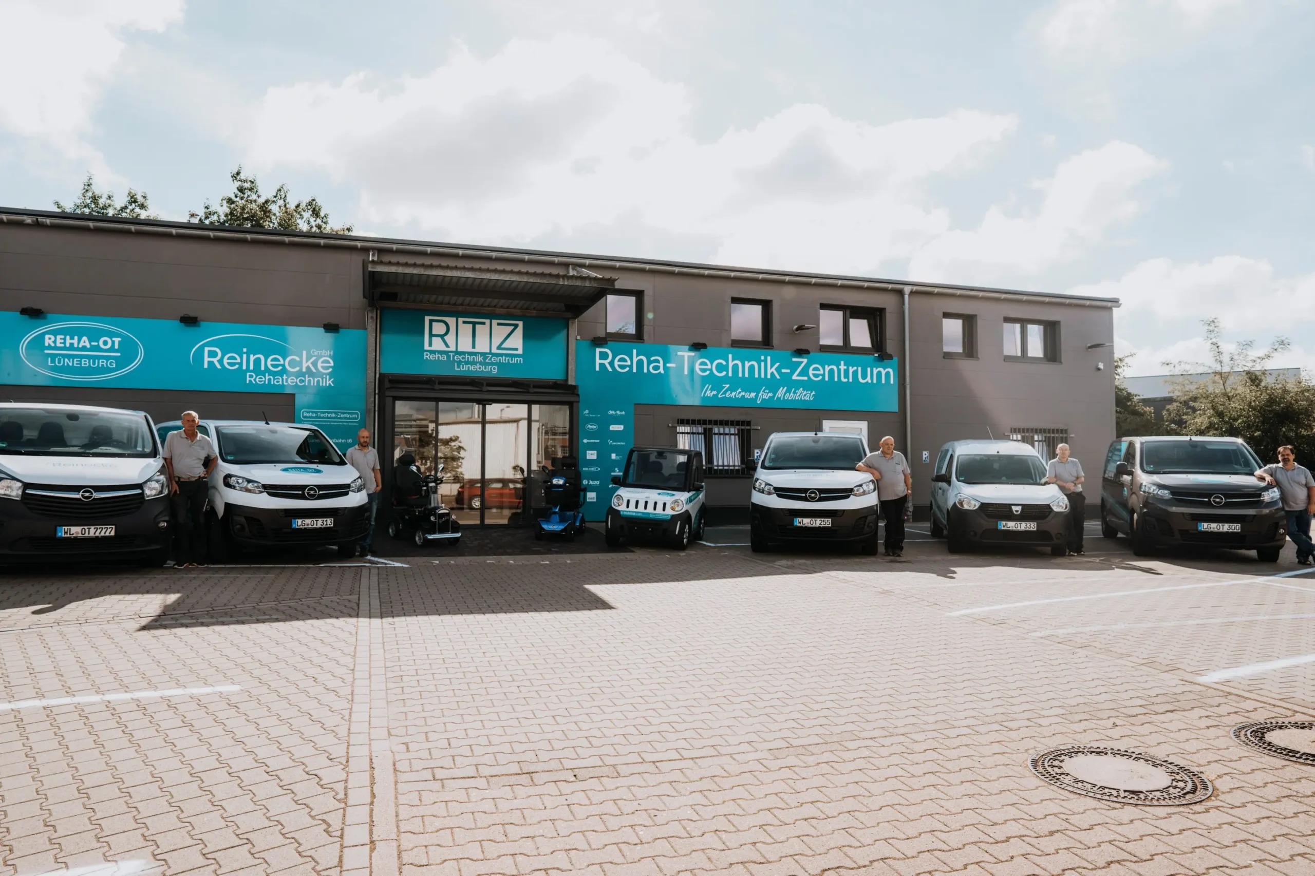 Reha-Technik-Zentrum Lüneburg mit fünf Transportern und einem E-Scooter davor. Sanitätshaus, Rehatechnik.