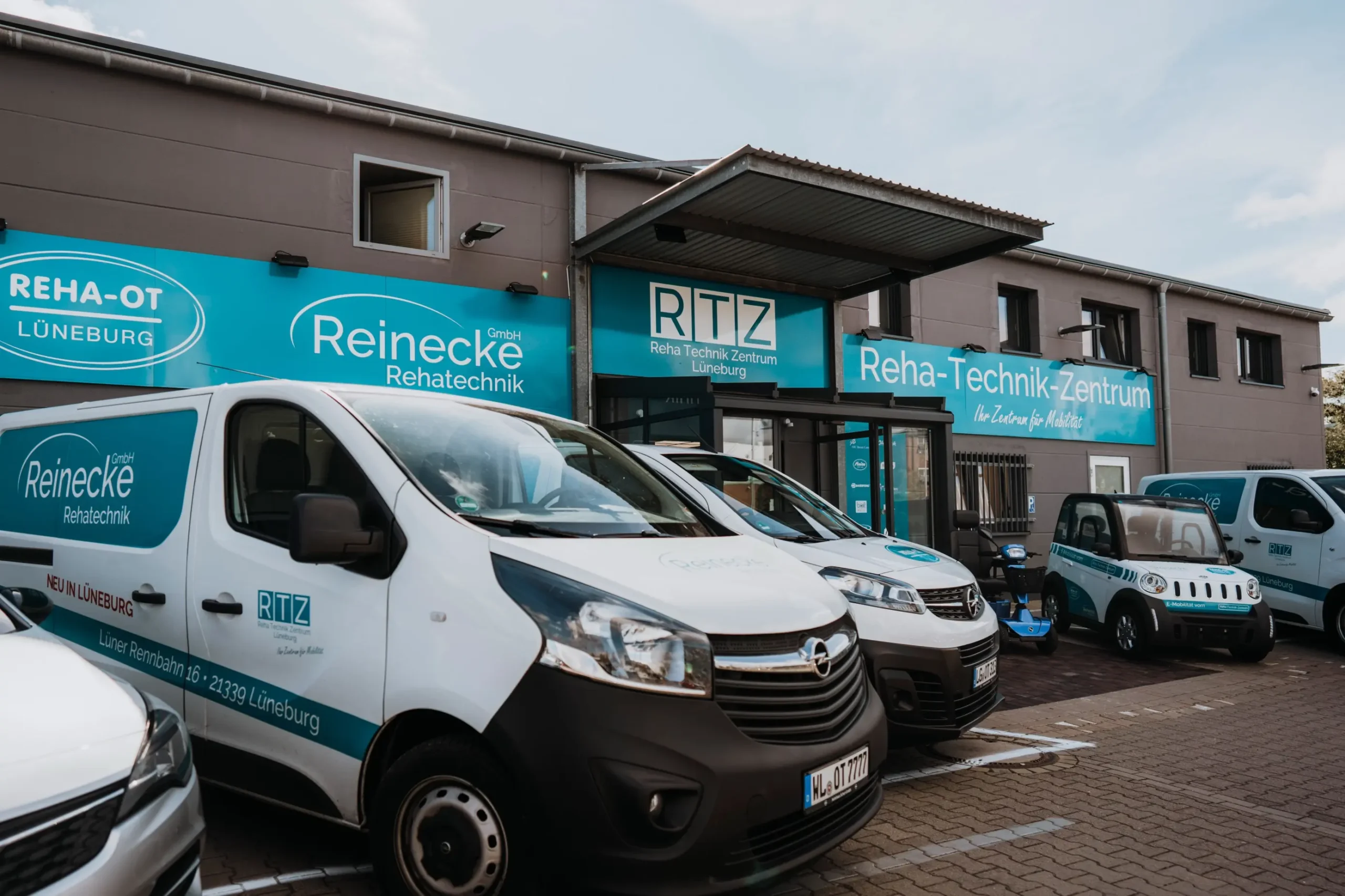 Zwei Rehatechnik-Fahrzeuge vor dem Reha-OT-Zentrum in Lüneburg.