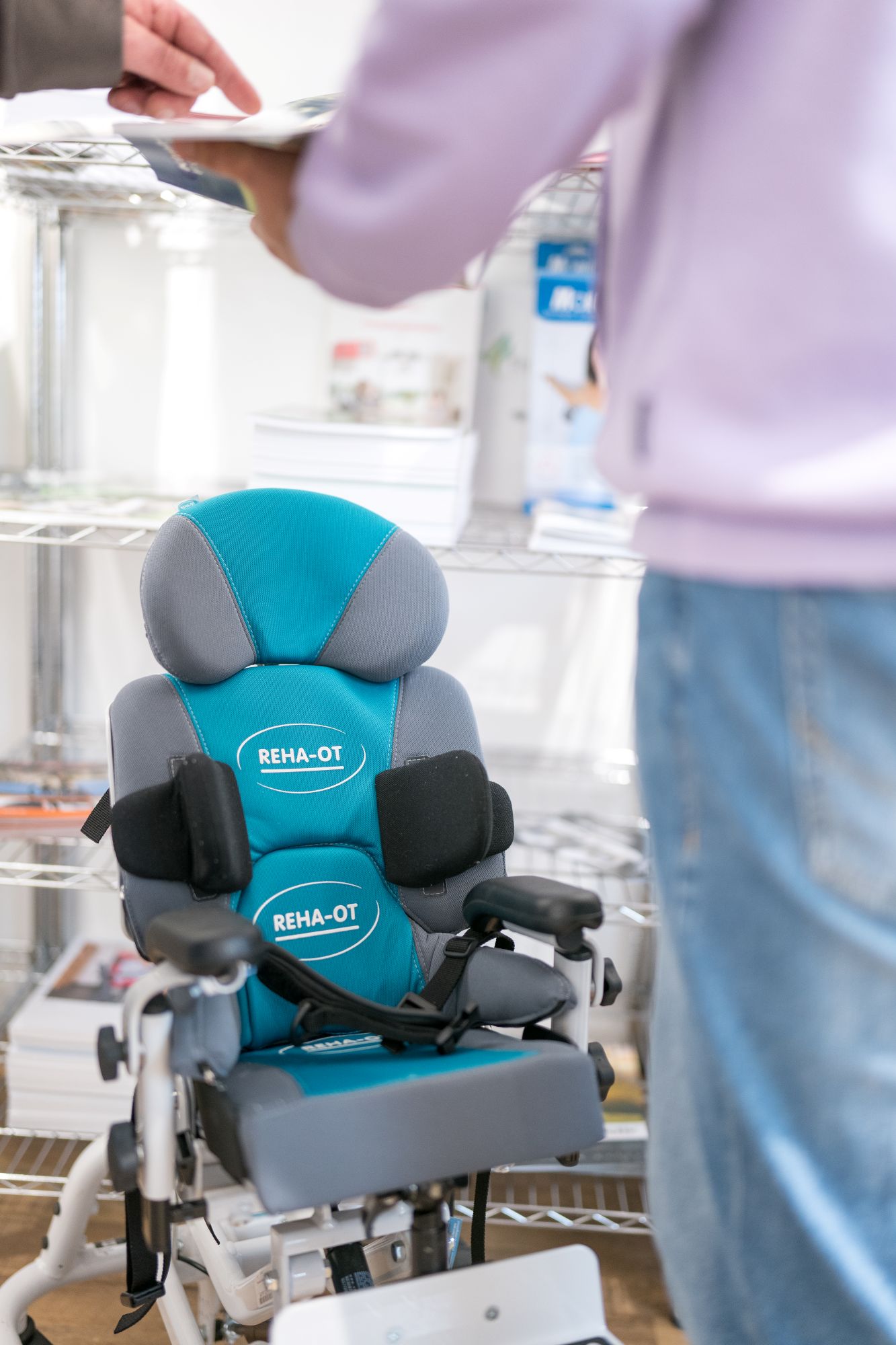 Eine Person zeigt auf einen Reha-OT Rollstuhl in einem Sanitätshaus.